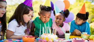 Cute Children Blowing Together On The Candle