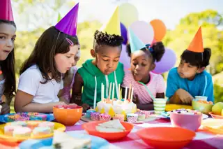 Cute Children Blowing Together On The Candle