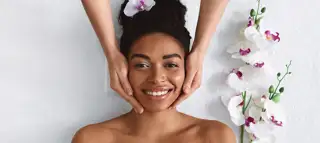 Beautician Making Face Massage For Happy Black Lady