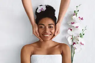 Beautician Making Face Massage For Happy Black Lady